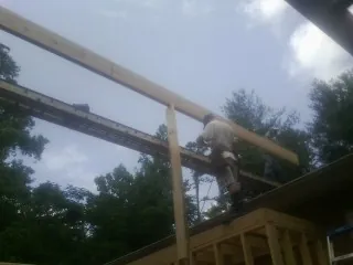 Carpenter setting a ridge beam over a new addition frame — Ice Dam Removal by Roofing Brothers in Boys Town