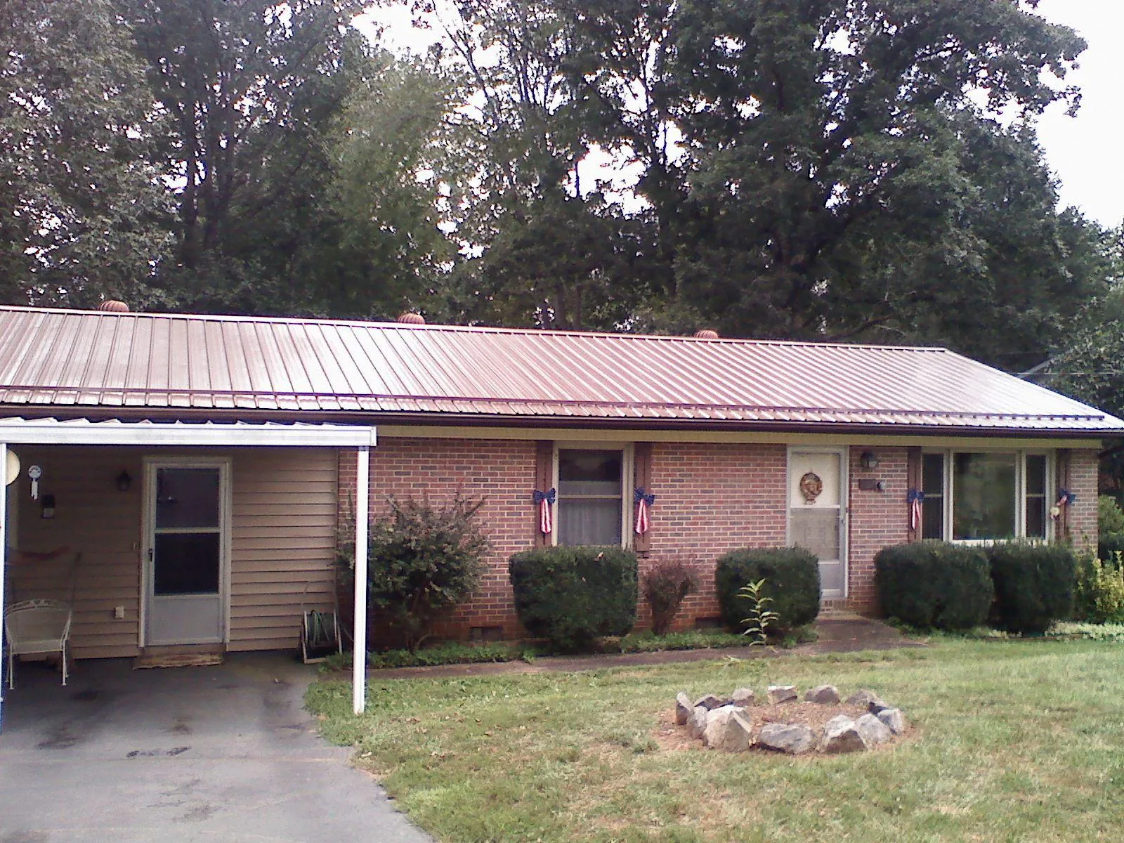 Bronze metal roof and carport on a brick ranch home — Roof Repair work by our crew in Boys Town