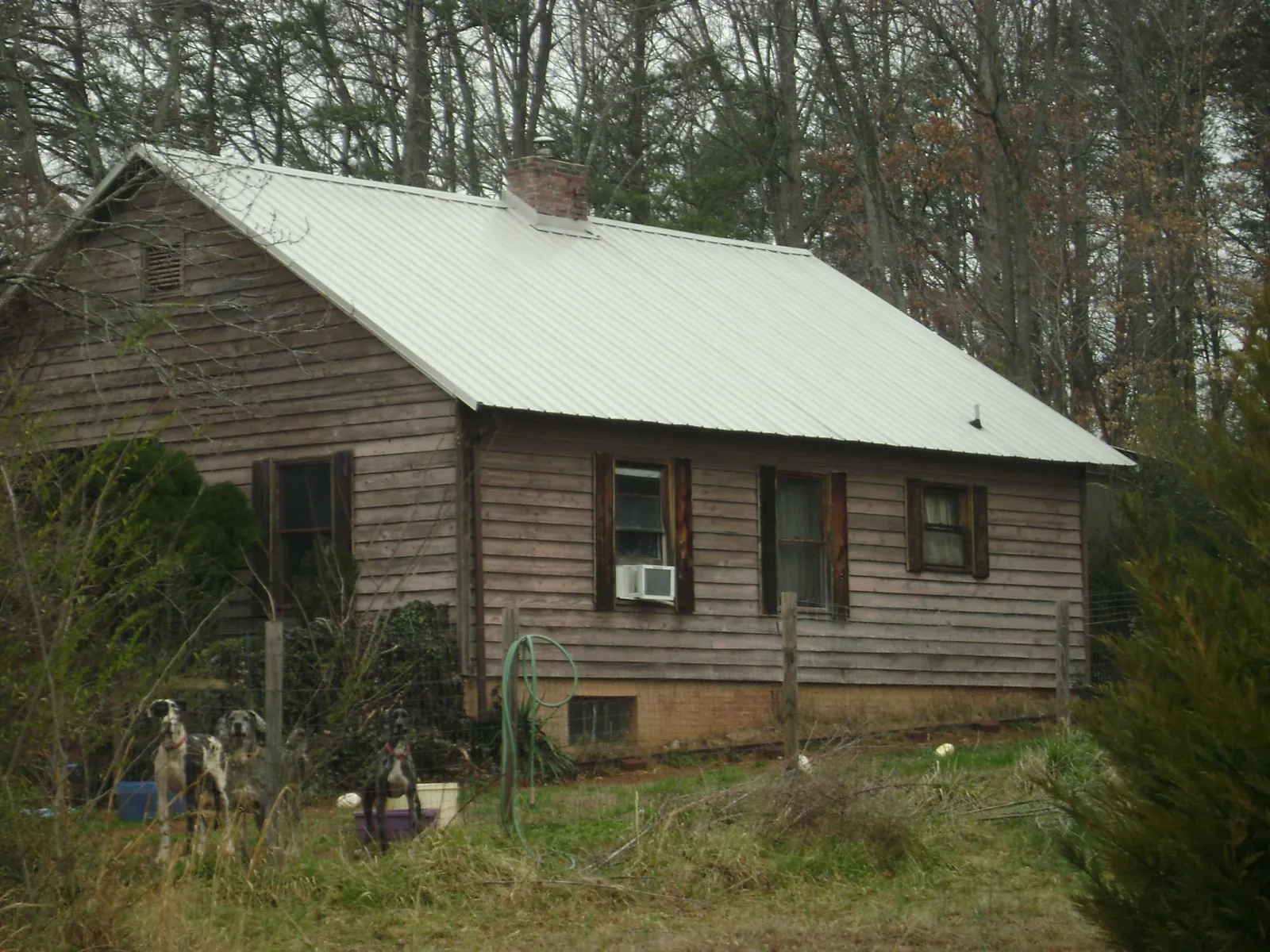 White metal roof on an old wood sided farmhouse, from a Metal Roof Installation job in Boys Town